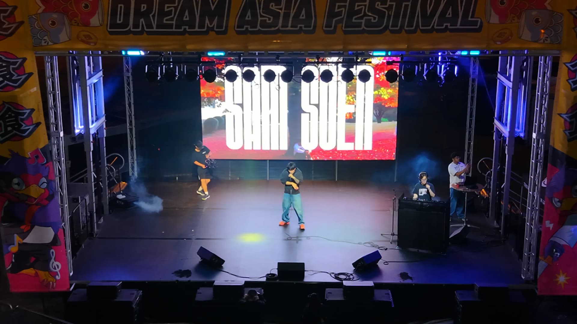 Sam Suen mid-set at DreamAsia Fest, stage visuals and crowd behind him