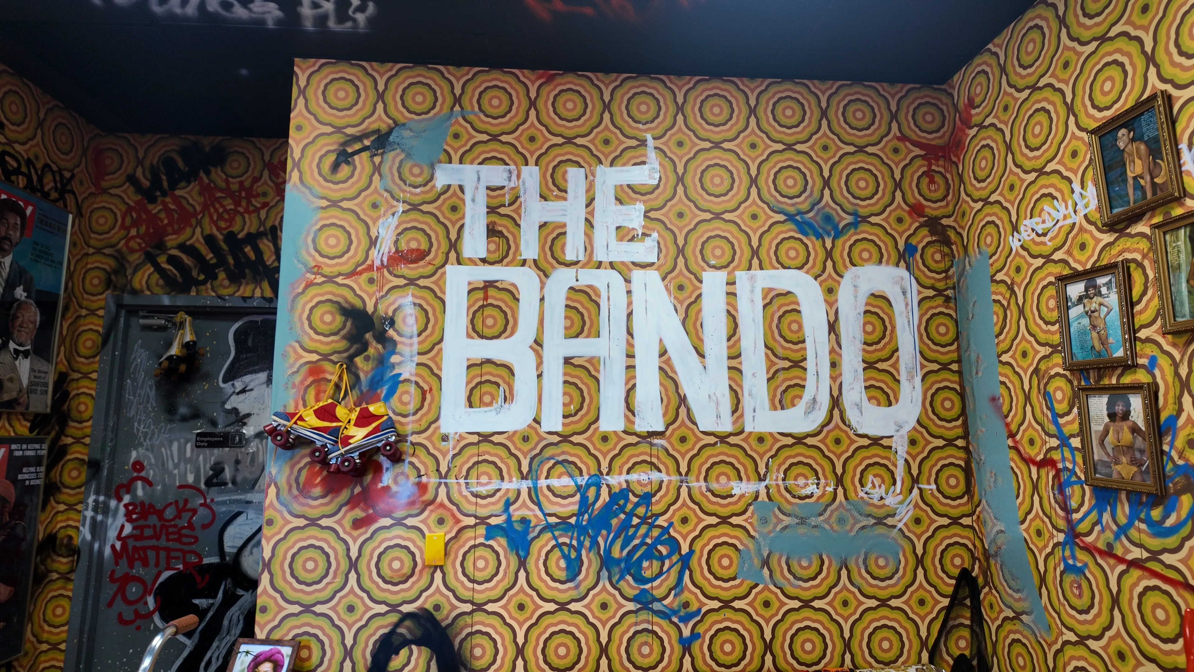 The Bando signature wall featuring the restaurant name in bold white letters against vibrant patterned wallpaper