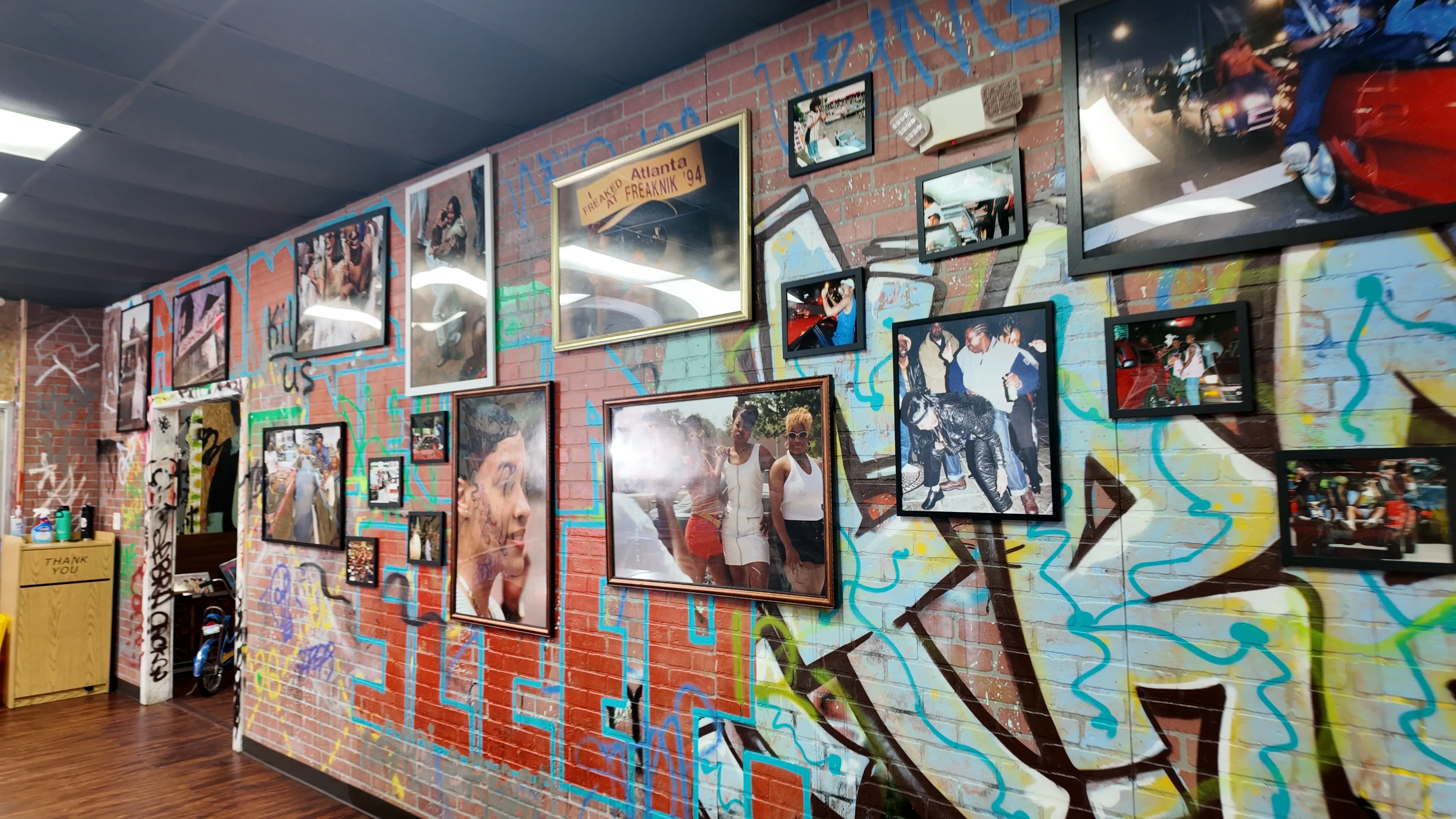 The Bando gallery wall showcasing Black history photographs and graffiti art on exposed brick